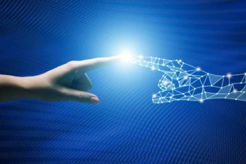 Fotos-Tracey-en-Solis-1-768×432 Human handed touching an AI hand with a bright light in the middle