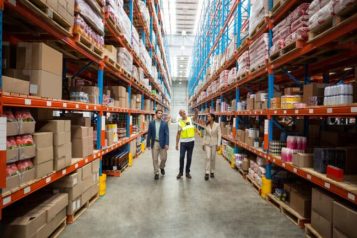 How-to-Choose-Fulfillment-Center-Location-1-768×432 Warehouse employees walking through a warehouse filled with boxes