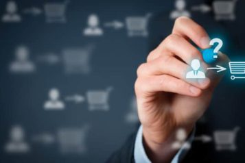 Person writing with a blue marker with in front of the marker an icon of a person pointing at a shopping cart and a question mark above it