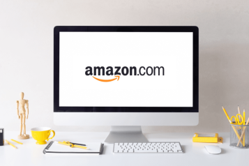 Desktop screen displaying Amazon logo on desk with office supplies